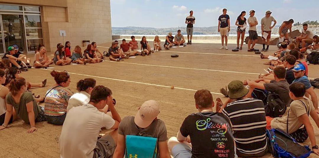 Teens sitting in circle listening to presenters