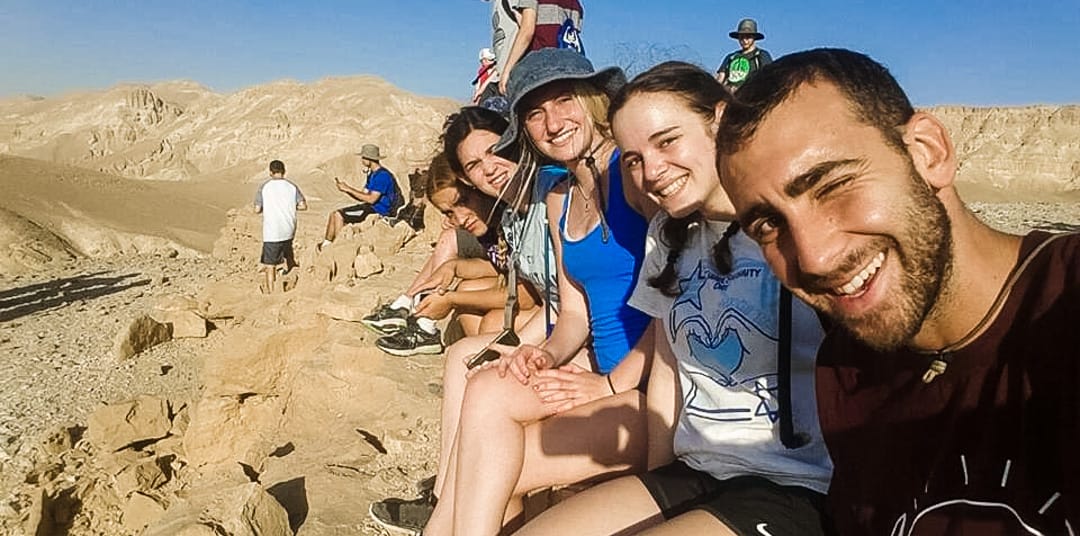 Group of teens sitting on hillside in Israel